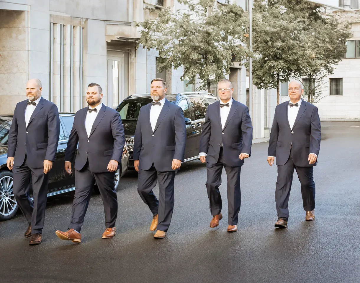 Das Chauffeur-Team der Agentur Maximal vor einer Limousine